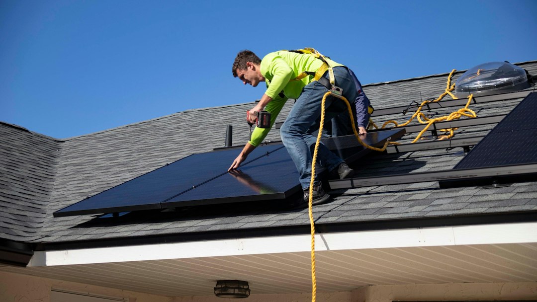 Technicien installant des panneaux solaires en toiture